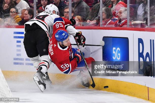 Sam Lafferty of the Chicago Blackhawks drives Jesse Ylonen of the Montreal Canadiens into the boards during the first period at Centre Bell on...