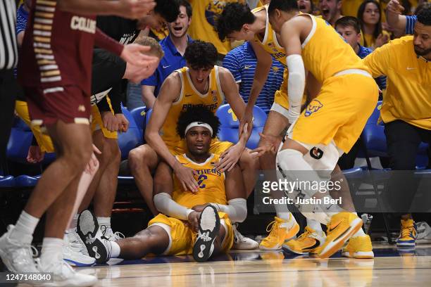 Blake Hinson of the Pittsburgh Panthers is mobbed by teammates after falling to the ground while being fouled in the act of shooting a three point...