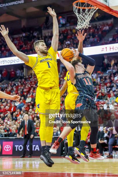 Wisconsin guard Max Klesmit attempts a shot in front of Michigan center Hunter Dickinson during a college basketball game between the University of...