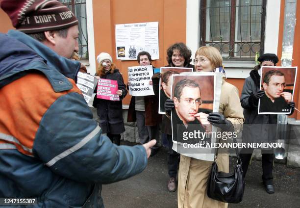 Municipal utility worker talks with supporters of jailed founder of the partly re-nationalized Russian oil giant Yukos, Mikhail Khodorkovsky holding...