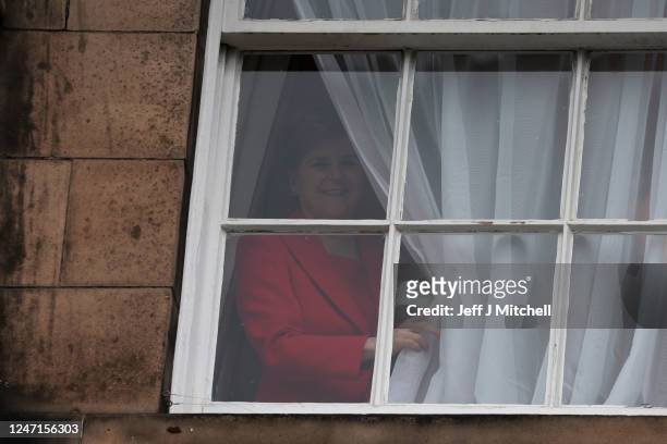 Nicola Sturgeon appears at a window, after holding a press conference, as people gather outside of Bute House on February 15, 2023 in Edinburgh,...