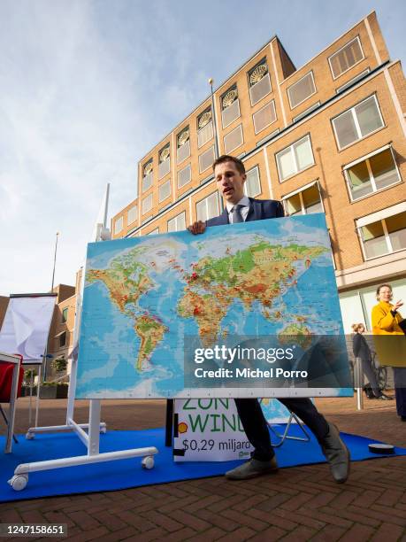 Daan van der Werf walks off with a world map with countless red pins of world wide Shell operations after a fake boardroom meeting outside the Dutch...