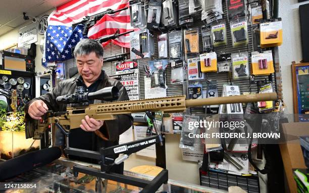 Gun shop owner David Liu holds a British-manufactured Accuracy International sniper rifle at his store in Arcadia, California, on February 10, 2023....