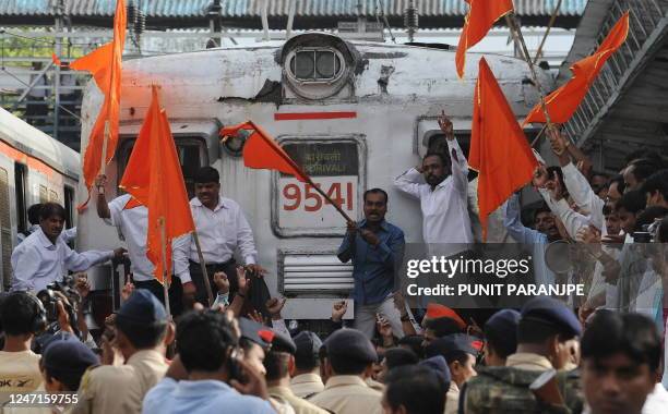 India's Shiv Sena party workers shout slogans as they stop local trains during a nationwide strike in protest of fuel price hikes in Mumbai on July...