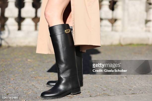 Model and influencer Marlies Pia Pfeifhofer is wearing Trench Coat by COS, riding boots by DIOR, matching scrunchie by Zara during a street style...