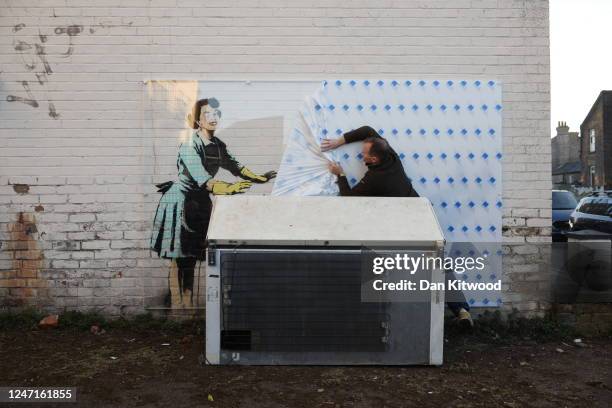 Protective screen is placed over the new artwork called 'Valentine’s Day mascara' claimed to be by Banksy as the refrigerator was replaced by Thanet...