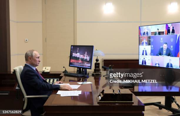 Russian President Vladimir Putin chairs a meeting with members of the government via a video link at the Novo-Ogaryovo state residence, outside...