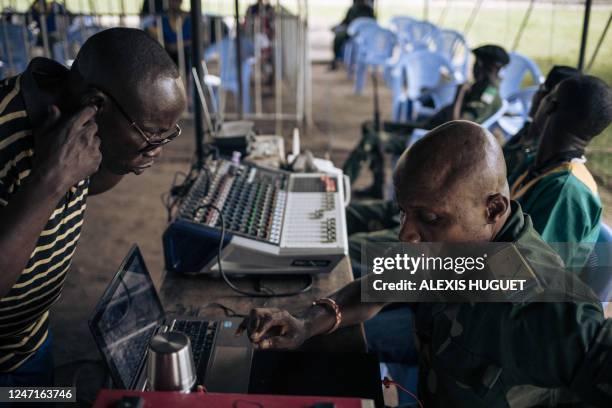 Military court technicians make adjustments during a court hearing for the murder of former Italian ambassador to the Democratic Republic of Congo...