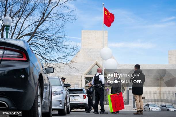 Rev. Patrick Mahoney, holding two white balloons, speaks with US Secret Service as he protests against the Chinese government over the alleged...