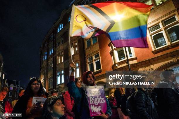 People hold placards and flags as they shout slogans during a vigil, in London, on February 15, 2023 in tribute of 16-year-old transgender teen,...