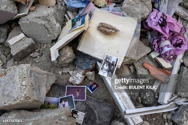 Family pictures lie on the rubble of collapsed buildings in Hatay on February 15 nine days after a 7,8-magnitude earthquake struck parts of Turkey...