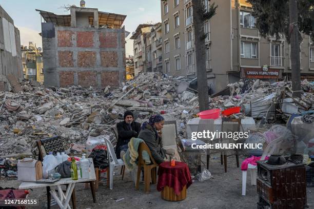Displaced quake-hit residents sit with their belongings near the collapsed buildings in Hatay on February 15 nine days after a 7,8-magnitude...