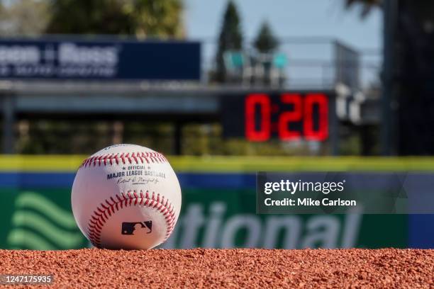 Detail shot of an Official Rawlings baseball on the field with a pitch clock in the background as new rule changes are demonstrated to assembled...