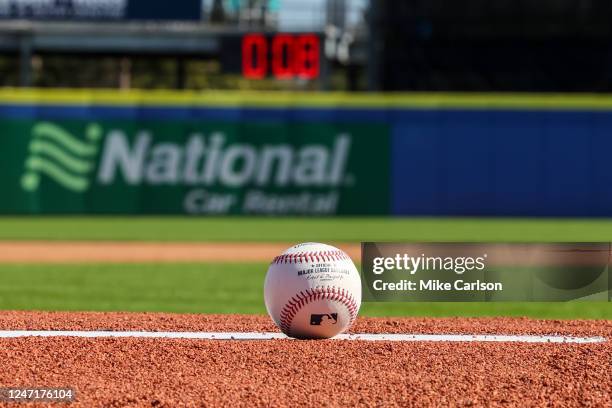 Detail shot of an Official Rawlings baseball on the field with a pitch clock in the background as new rule changes are demonstrated to assembled...