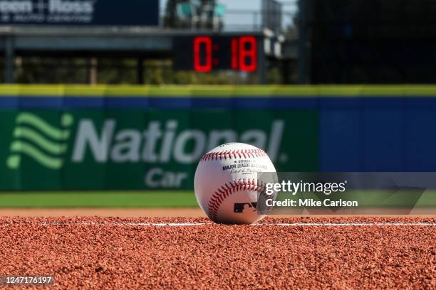 Detail shot of an Official Rawlings baseball on the field with a pitch clock in the background as new rule changes are demonstrated to assembled...