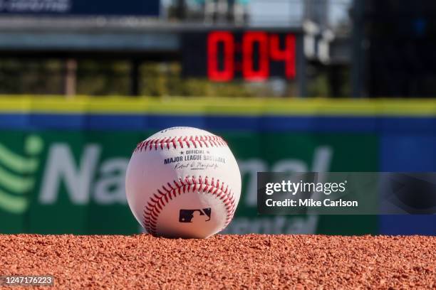 Detail shot of an Official Rawlings baseball on the field with a pitch clock in the background as new rule changes are demonstrated to assembled...