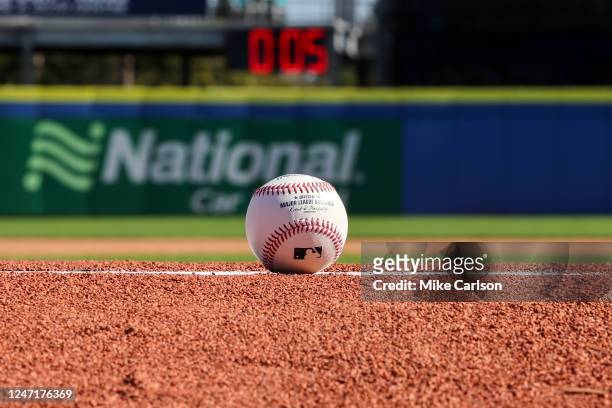 Detail shot of an Official Rawlings baseball on the field with a pitch clock in the background as new rule changes are demonstrated to assembled...