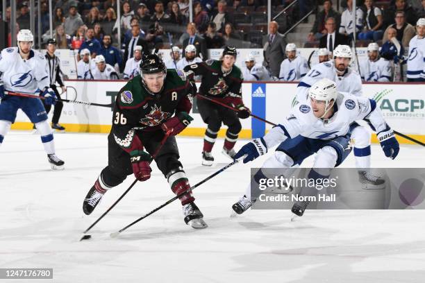 Christian Fischer of the Arizona Coyotes takes a shot on goal while being defended by Haydn Fleury of the Tampa Bay Lightning during the first period...