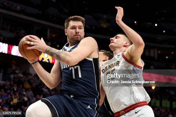 Luka Doncic of the Dallas Mavericks grabs a rebound against Nikola Jokic of the Denver Nuggets at Ball Arena on February 15, 2023 in Denver,...