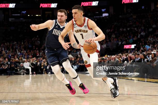 Michael Porter Jr. #1 of the Denver Nuggets drives past Luka Doncic of the Dallas Mavericks at Ball Arena on February 15, 2023 in Denver, Colorado....