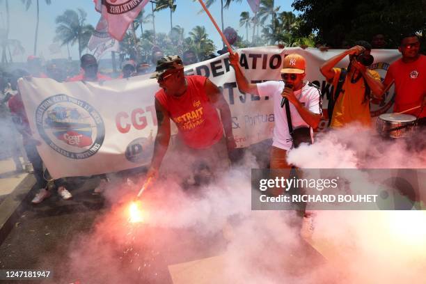 Protesters hold smoke flares as they take part in a demonstration on the fifth day of nationwide rallies organised since the start of the year,...