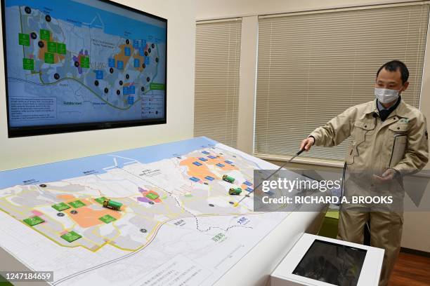 This photo taken on February 14, 2023 shows Yoshitomo Mori, section head of the Department of Interim Storage Facility, pointing to a map...