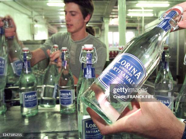 Workers line up bottles in the family-operated Geyer Brothers factory producing sparkling lemon-taste water, called "limonade" in France, in Munster,...