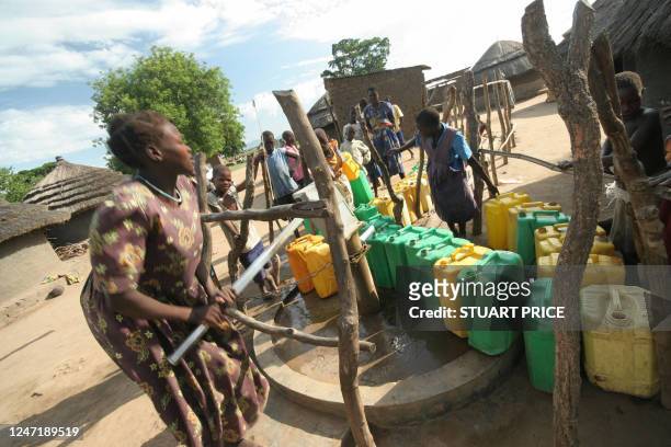 Woman pumps water from a borehole 10 April 2006 in Patongo internally displaced people's camp in Pader District approximately 350km north of the...