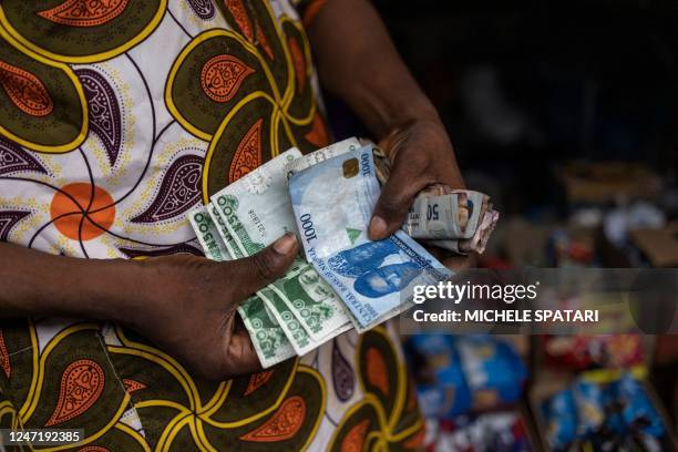 Vendor shows old and newly introduced Nigerian Naira banknotes in a market in Lagos on February 16, 2023. - Nigeria has been struggling with a...