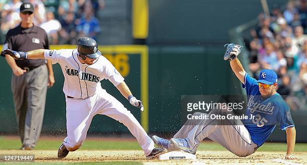 Dustin Ackley of the Seattle Mariners is doubled off of first on a ball hit by Mike Carp as first baseman Eric Hosmer of the Kansas City Royals...