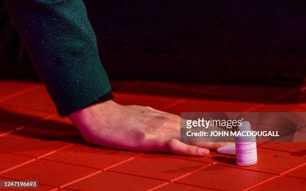 Close-up shows the glued hand of an activist of the environmental group "Last Generation" near the red carpet at the premiere of the film "She Came...