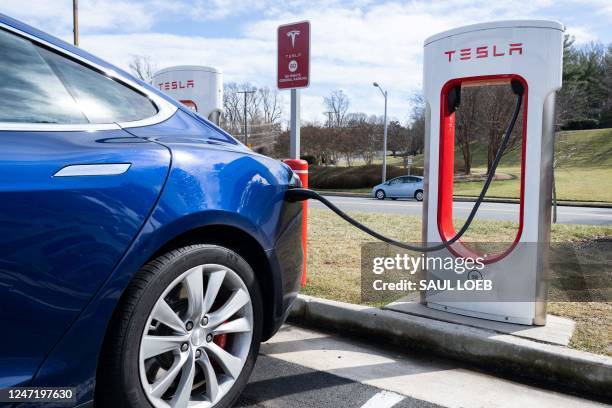 Tesla Model S sedan is plugged into a Tesla Supercharger electrical vehicle charging station in Falls Church, Virginia, February 13, 2023.