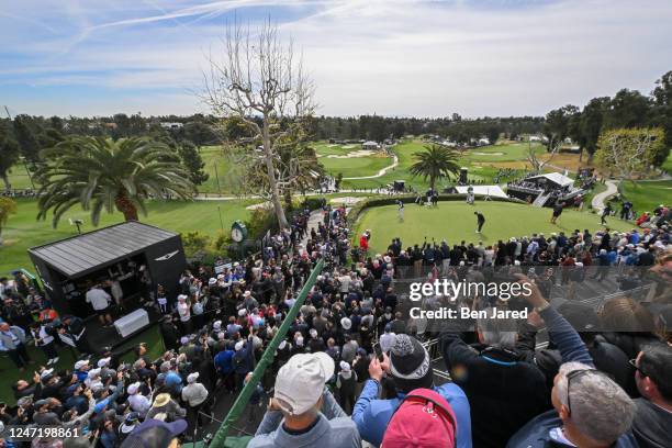 Fans watch as Tiger Woods practices on the putting green during the first round of The Genesis Invitational at Riviera Country Club on February 16,...