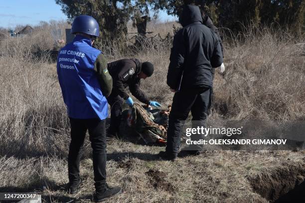 Graphic content / A war crimes prosecutor and Ukrainian police forensic team examine the exhumed remains of Olena Trofimova, 51-year-old, killed on...