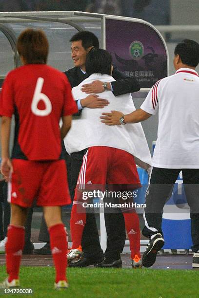 Li Xiaopeng, coach of China and Han Duan hag each other during the London Olympic Women's Football Asian Qualifier match between Japan and China at...