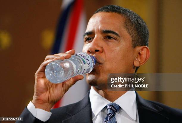 President Barack Obama drinks from a bottle of water during a news conference with Britain's Prime Minister Gordon Brown at the Foreign and...