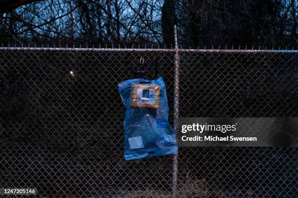 An air quality monitor hangs on a fence near the site of the derailment on February 16, 2023 in East Palestine, Ohio. On February 3rd, a Norfolk...