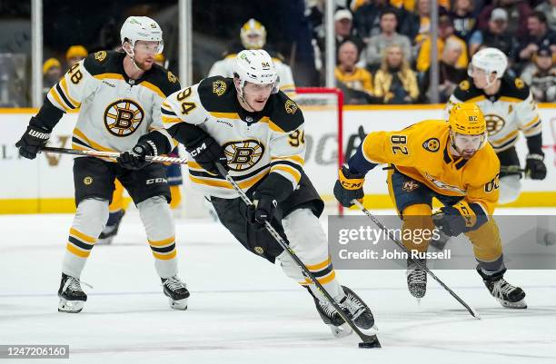 Jakub Lauko of the Boston Bruins skates away from Tommy Novak of the Nashville Predators during an NHL game at Bridgestone Arena on February 16, 2023...