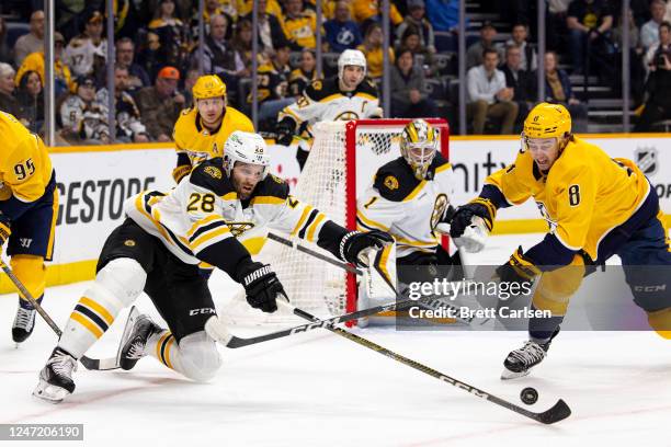 Derek Forbort of the Boston Bruins and Cody Glass of the Nashville Predators vie for the puck during the first period at Bridgestone Arena on...