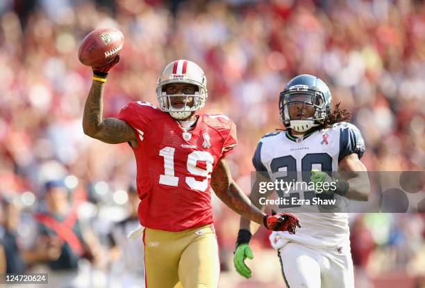 Ted Ginn of the San Francisco 49ers outruns Earl Thomas of the Seattle Seahawks on his way to scoring a touchdown on a kickoff return during their...