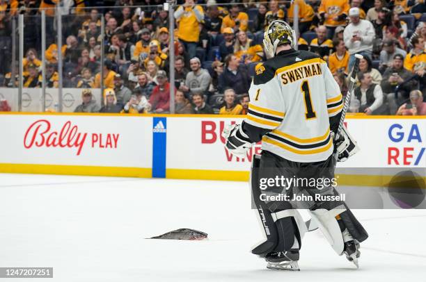 Jeremy Swayman of the Boston Bruins skates by a catfish that was tossed onto the ice late in the second period during an NHL game against the...