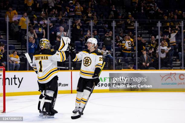 Brandon Carlo and Jeremy Swayman of the Boston Bruins celebrate a shutout victory against the Nashville Predators after the third period at...