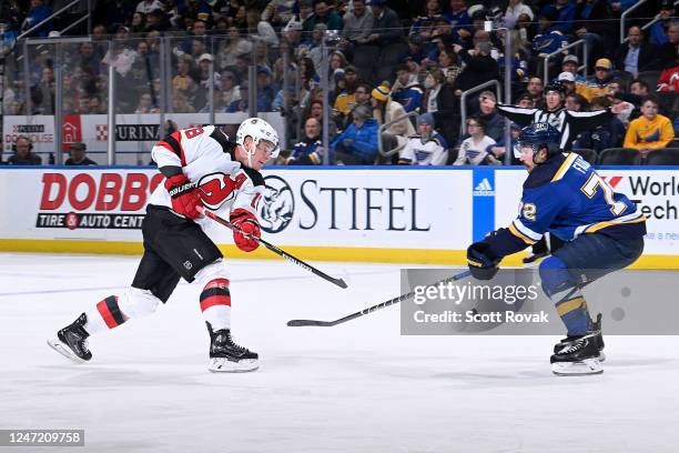 Ondrej Palat of the New Jersey Devils takes a shot as Justin Faulk of the St. Louis Blues defends at the Enterprise Center on February 16, 2023 in...