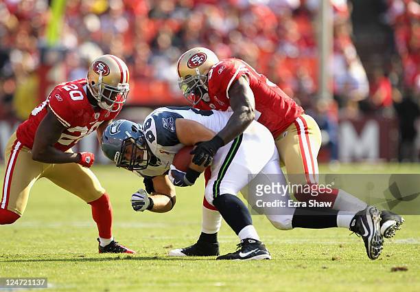 Zach Miller of the Seattle Seahawks is tackled by Patrick Willis and Madieu Williams of the San Francisco 49ers during their season opener at...