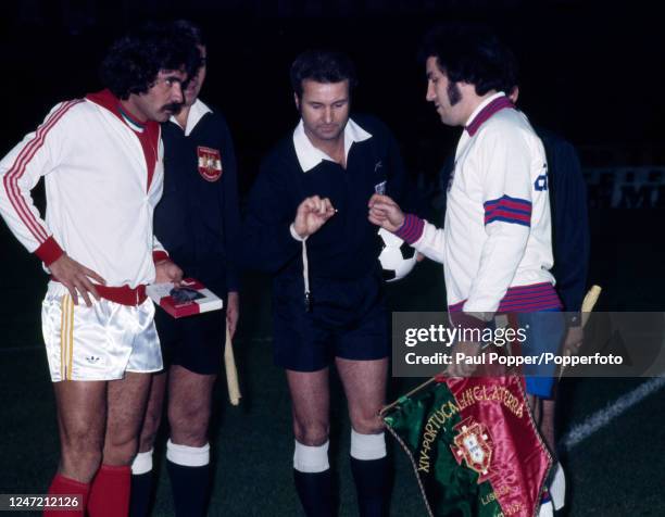 Austrian referee Erich Linemayr adjudicates the coin toss for captain's Gerry Francis of England and Toni of Portugal before the UEFA Euro 1976...