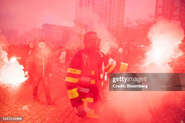 Demonstrators let off flares at a protest against government plans to revamp the pension system, in Paris, France, on Thursday, Feb. 16, 2023. French...