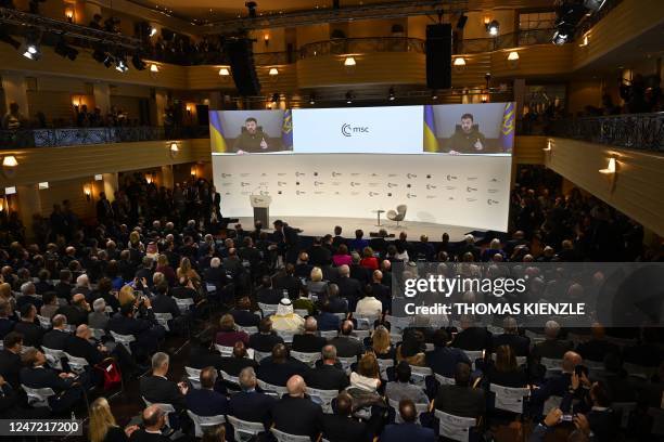 Participants watch Ukrainian President Volodymyr Zelensky on a screen during the Munich Security Conference in Munich, southern Germany, on February...