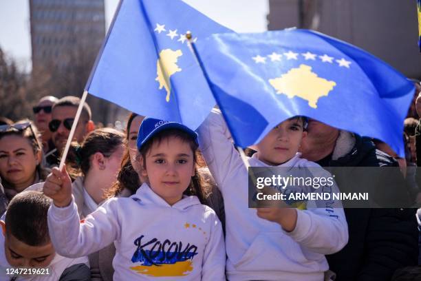 Kosovo Albanian children wave Kosovo flags as they watch the military parade during celebrations marking the 15th anniversary of Kosovo's declaration...