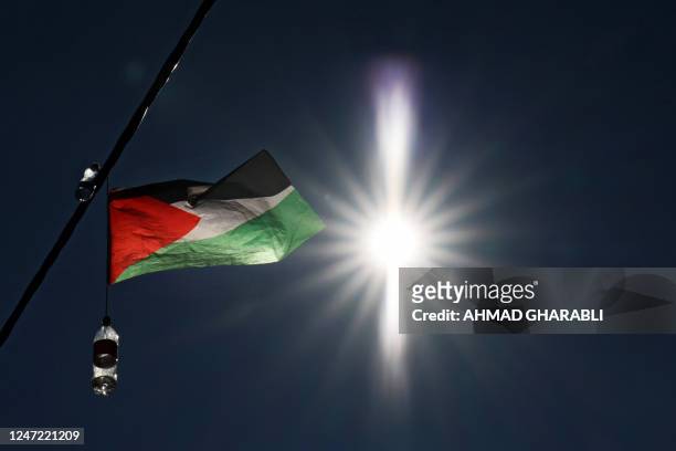 Palestinian national flag hangs on an electric cable in the Arab neighbourhood of Silwan in Israeli-annexed east Jerusalem on February 17, 2023. -...
