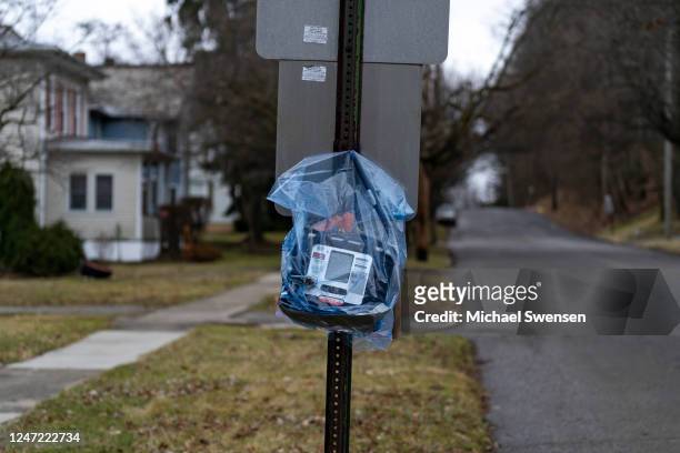 An air quality monitor hangs on a stop sign near the site of a train derailment prompting health concerns on February 17, 2023 in East Palestine,...